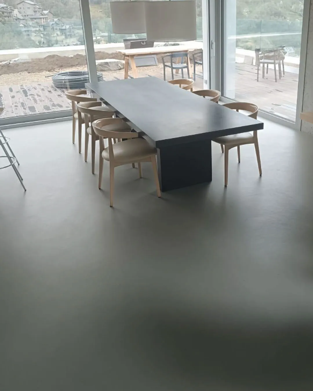 Laaja saumaton mikrosementtilattia ruokailutilassa.